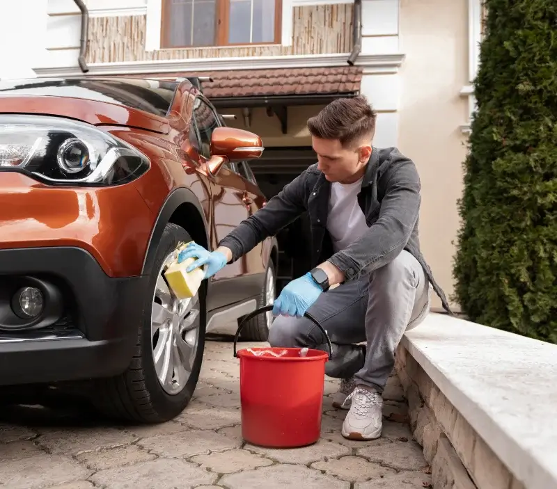Lavage auto à domicile Balan : professionnel intervenant sur un véhicule